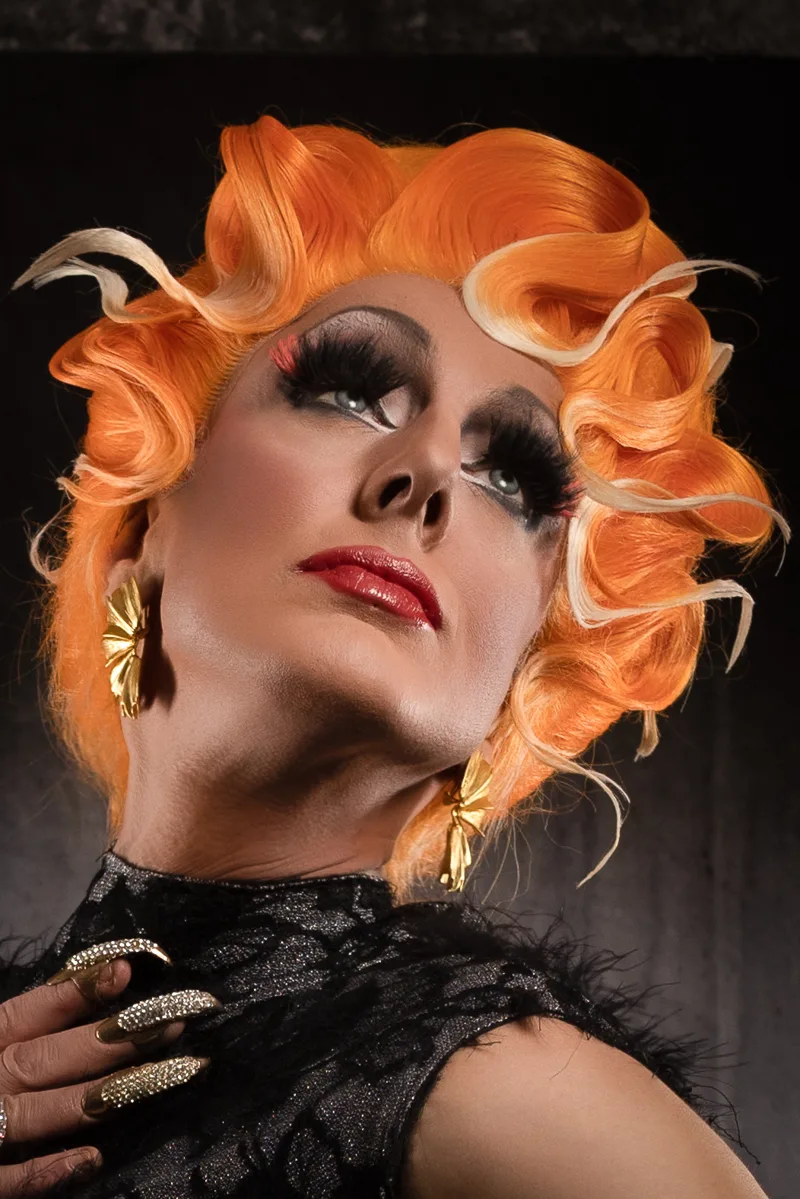 Portrait de Lady Maxx, artiste drag queen et transformiste à Paris, perruque rousse ondulée et bijoux dorés